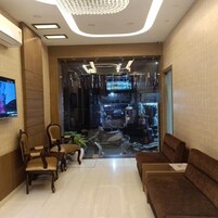 Un lobby moderno con zona de estar, televisor y escaparate de vidrio.