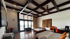 Une chambre d’hôtel avec deux lits, un bureau, une chaise et une grande fenêtre.