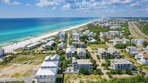 Zona residencial costera con propiedades frente al mar, una playa y una carretera que conduce al océano.