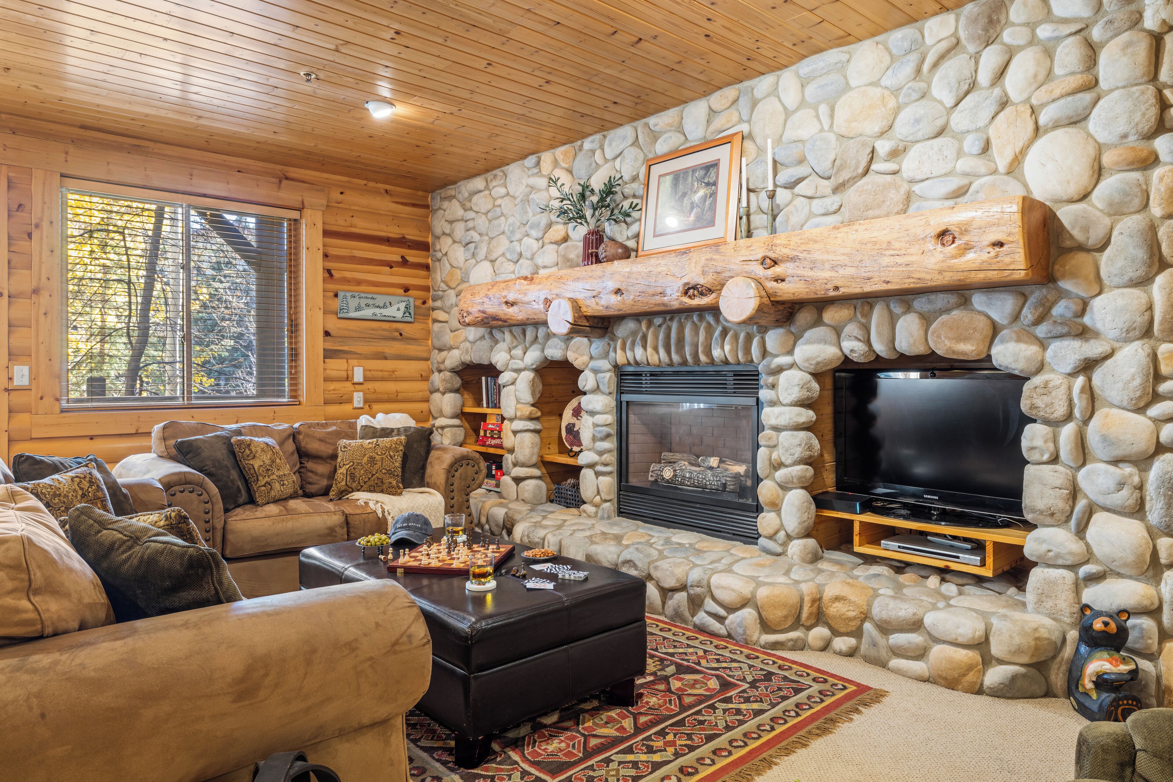 Una sala de estar acogedora con chimenea de piedra, televisor y asientos cómodos.