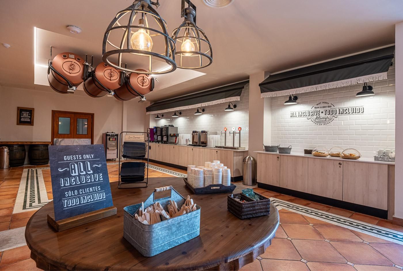 A modern kitchen with a coffee station, a sign indicating 'Guests Only', and a buffet setup.