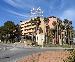 Een hotel met een bord waarop 'Estival Park Hotels' staat en een parkeerplaats ervoor.