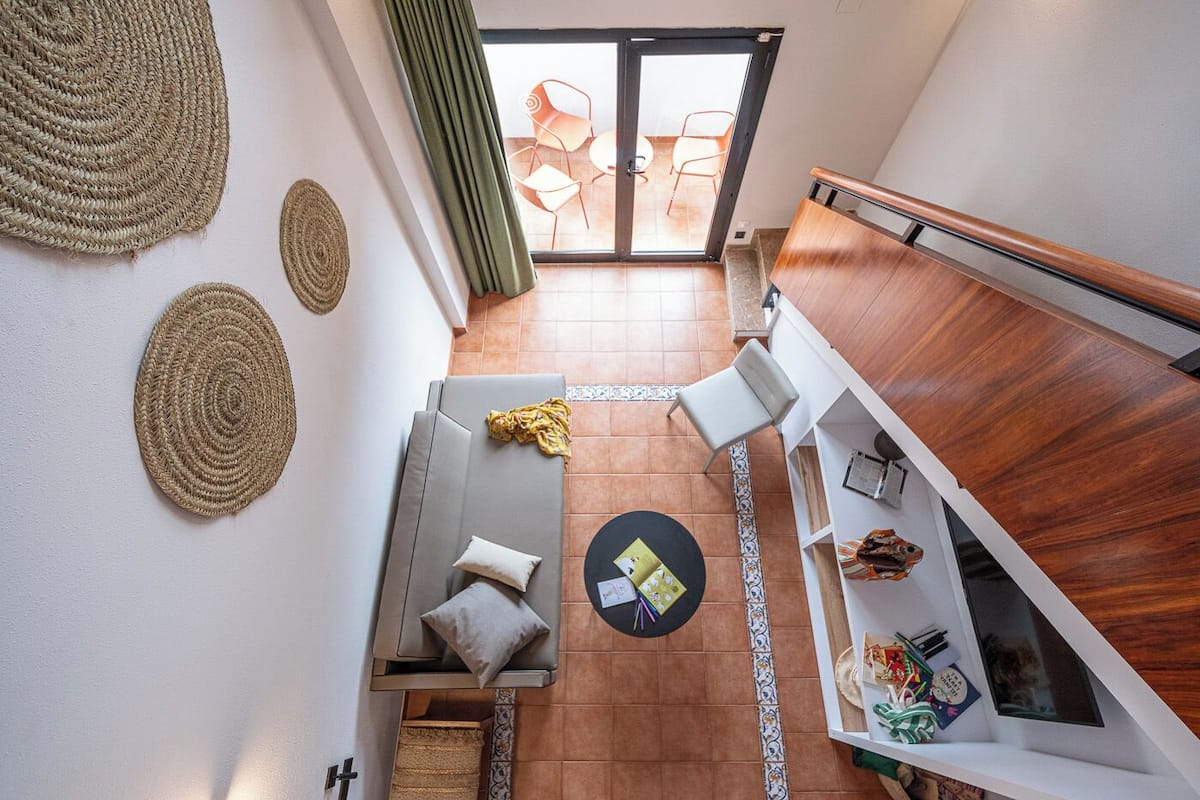 A modern living area with a sofa, a round table, and a wooden bench.