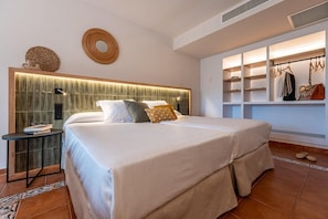 A modern bedroom with a large bed, a bedside table, a wardrobe, and decorative wall elements. - Estival Park Marena (Vila-Seca)