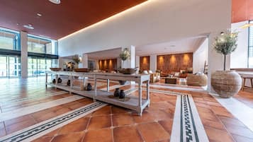 A spacious lobby with a central reception desk, seating areas, and a large decorative vase.