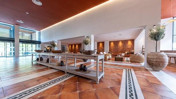 A spacious lobby with a central reception desk, seating areas, and a large decorative vase. - Estival Park Marena (Vila-Seca)