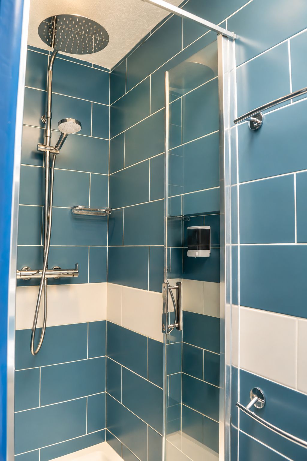 Eine Dusche mit Duschkopf und Wasserhahn an der Wand.
