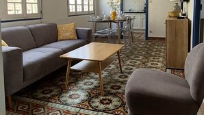Un salon comprenant un canapé, un fauteuil, une table basse et des carreaux de sol à motifs.
