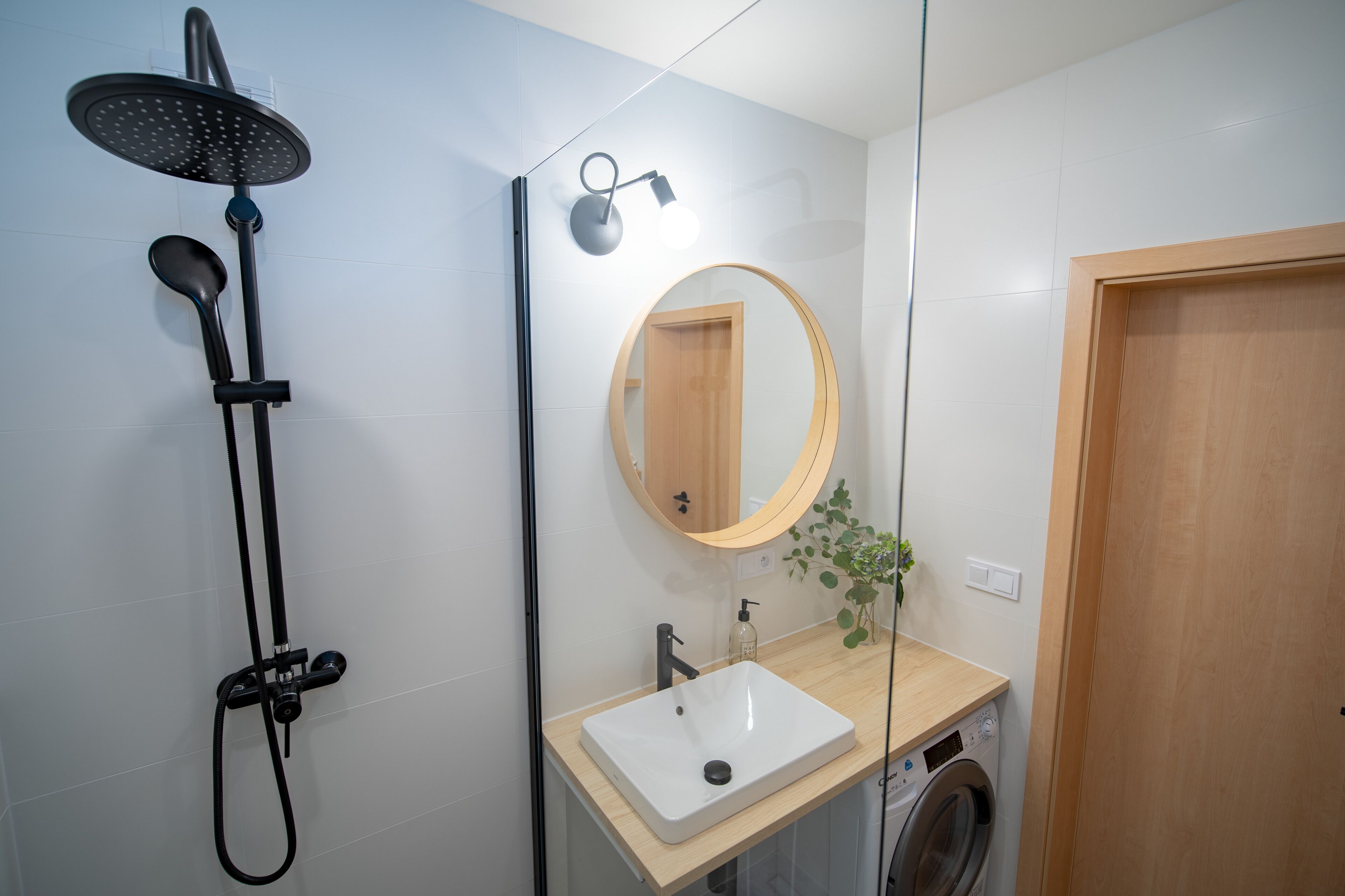 Un bagno moderno con doccia, lavabo e specchio.