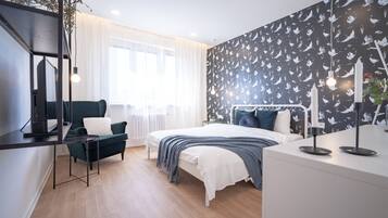 A modern bedroom with a bed, a desk, and a chair.