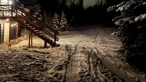 A cabin with a wooden staircase leading to a porch, surrounded by snow-covered trees and a snow-covered ground. - Barrel Sauna + Open Concept + Mountain Getaway = Relaxing Stay (Wasilla)