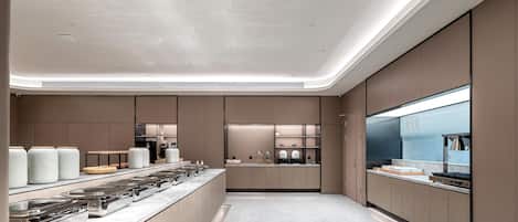 Een moderne keuken met een centraal eiland, inbouwapparatuur en een groot raam.