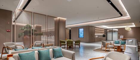 A modern interior with a sofa set, chairs, a dining area, and a kitchen.