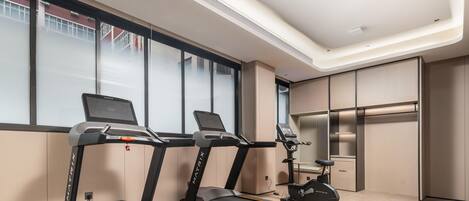 A modern fitness room with treadmills, an elliptical, and a stationary bike.