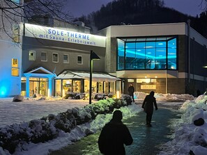 Rakennuksessa on kyltti, jossa lukee »SOLE-THERME mit Sauna-Erlebniswelt», ja siinä on lasijulkisivu.