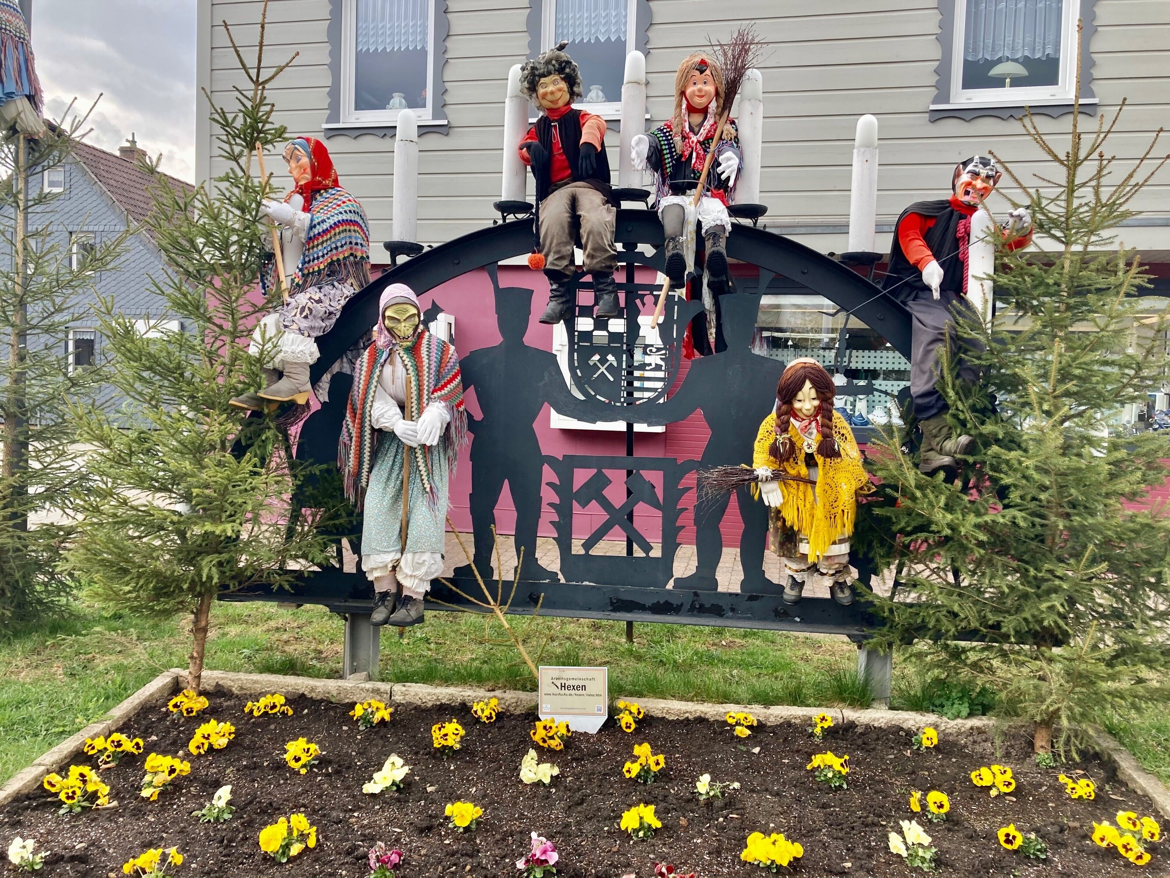 A decorative display with figures and a coat of arms, surrounded by flower beds.
