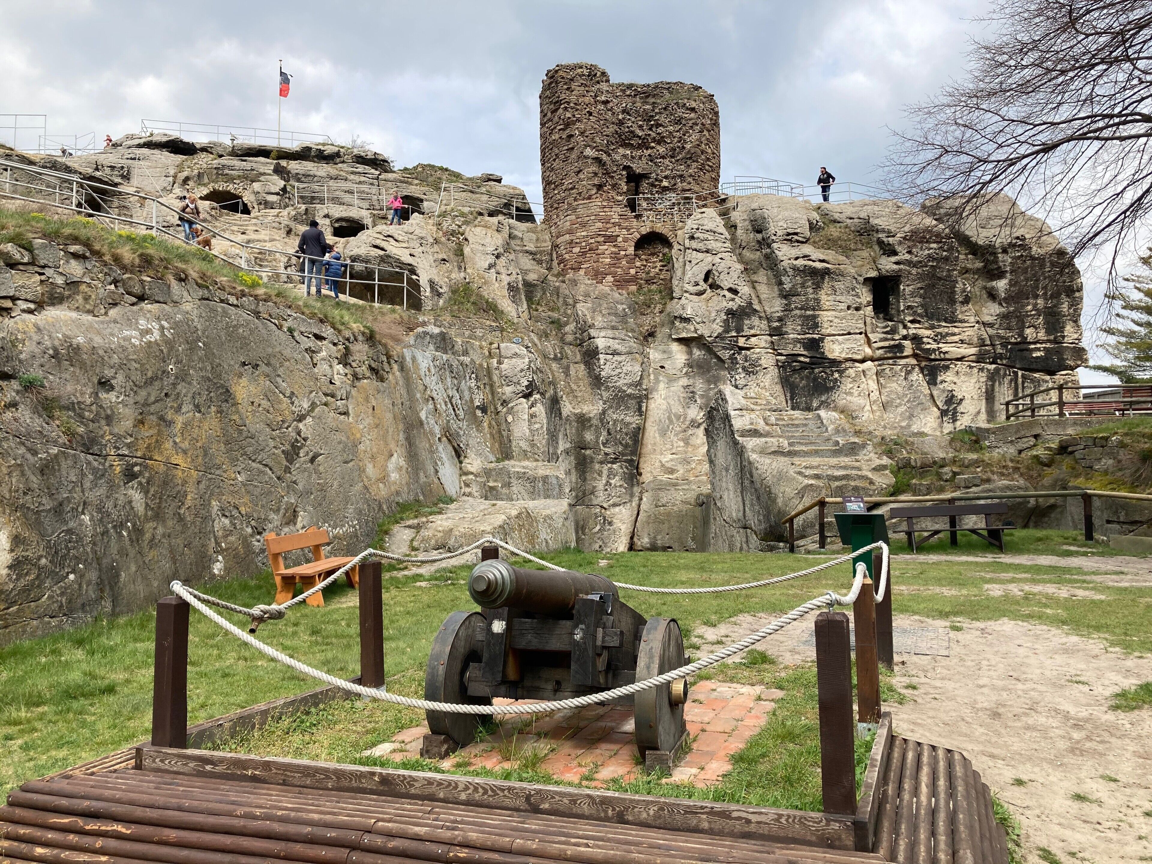 Un lugar histórico con un cañón, terreno rocoso y una bandera.