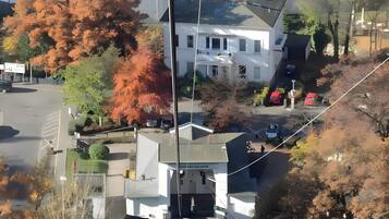 A multi-story building with a central entrance, surrounded by trees with autumn foliage.