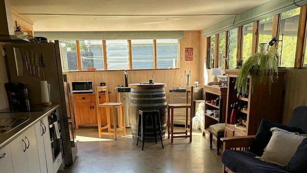 A spacious kitchen with wooden cabinets, a large window, and a bar area.