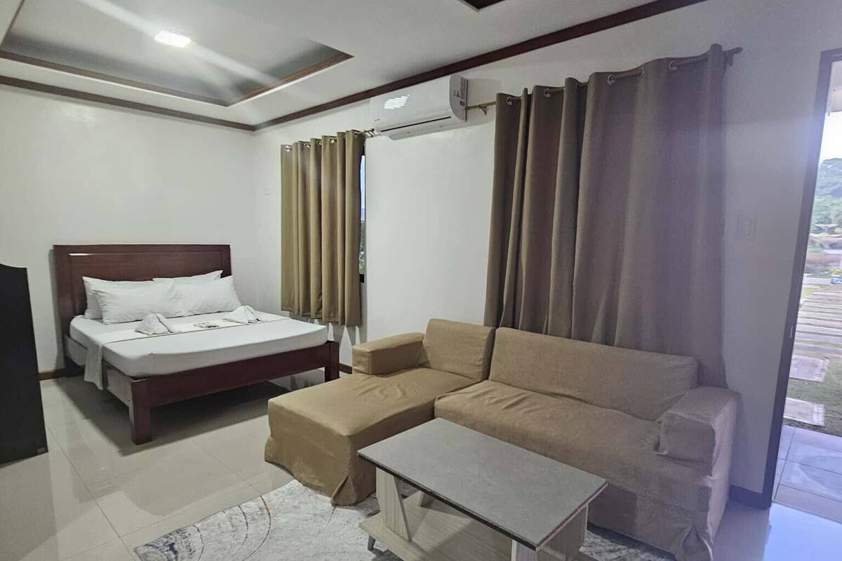 Une chambre d’hôtel moderne, équipée d’un lit, d’un canapé et d’une petite table.