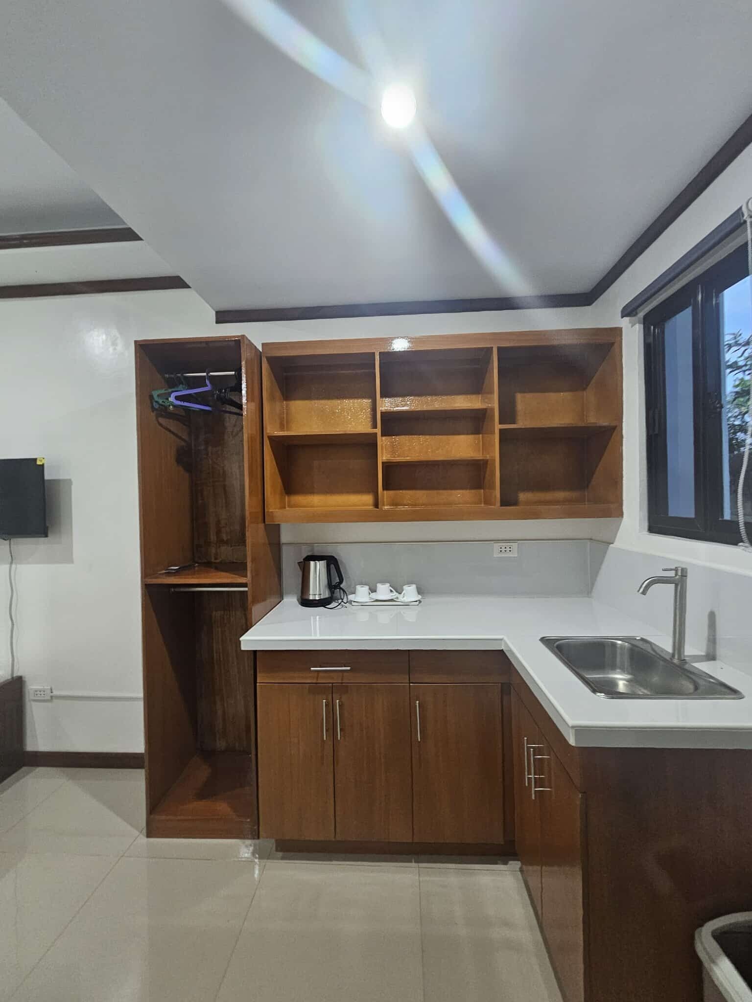 A modern kitchen with wooden cabinets, a white countertop, and a built-in sink.
