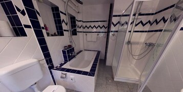 Un baño con bañera, ducha e inodoro.