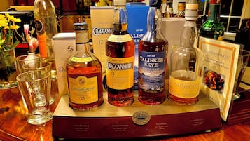 A selection of whisky bottles on a wooden tray with a label indicating 'Classic Malts of Scotland.'