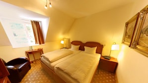 A hotel room with two beds, a desk, a chair, a window with curtains, and a painting on the wall. - Waldhotel Silbermühle (Horn-Bad Meinberg)
