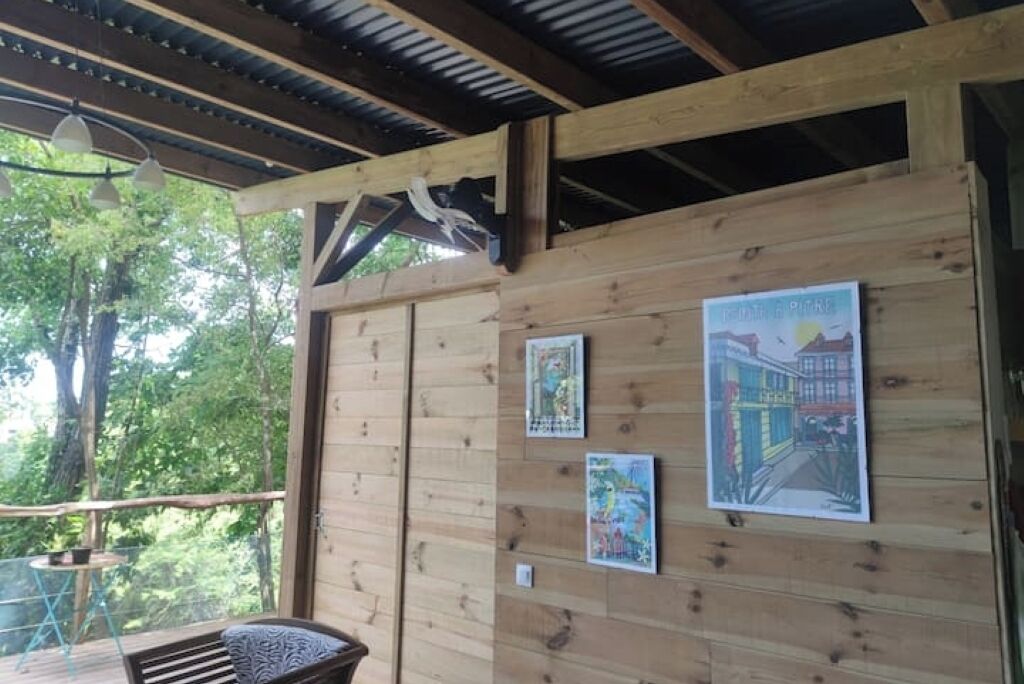 Une cabane en bois dotée d’un balcon, de murs en bois et d’un luminaire suspendu.