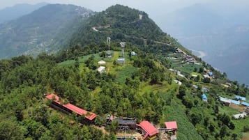 A mountainous landscape with a cluster of buildings, including a prominent red-roofed structure.