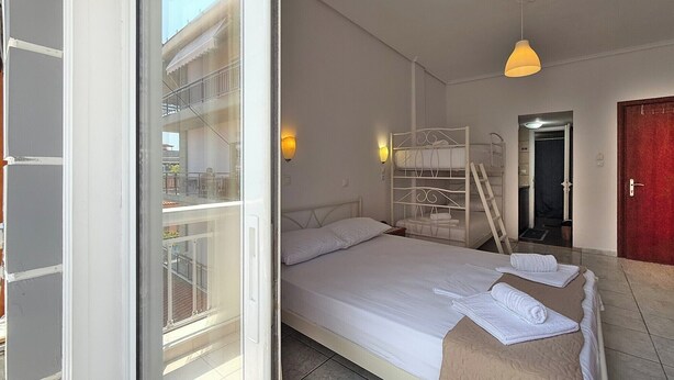 A hotel room with a bed, a window, a balcony, and a red door. - Meli Studio 304 – Comfort & Functionality for up to 4 Guest (Paralia)