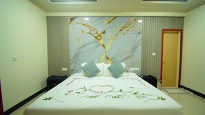 Una habitación de hotel con una cama grande, una pared con un diseño de árbol y una puerta.