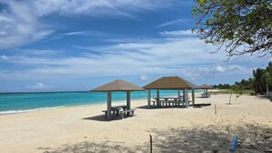 A beach with two gazebos, a clear blue sky, and a calm sea. - Gorgeous 7-bedroom house with AC in peaceful Shaviyani Atoll Milandhoo, Maldives (Milandhoo)