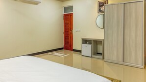 A hotel room with a bed, wardrobe, vanity, and a small desk. - Gorgeous 7-bedroom house with AC in peaceful Shaviyani Atoll Milandhoo, Maldives (Milandhoo)