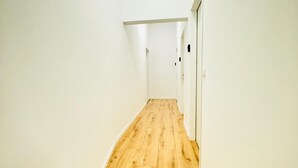 A narrow hallway with wooden flooring and white walls. - Elegant 4BR Apt Near Westbahnhof (Vienna)