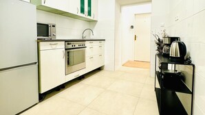 A modern kitchen with white cabinets, a built-in oven, a microwave, and a black countertop. - Elegant 4BR Apt Near Westbahnhof (Vienna)