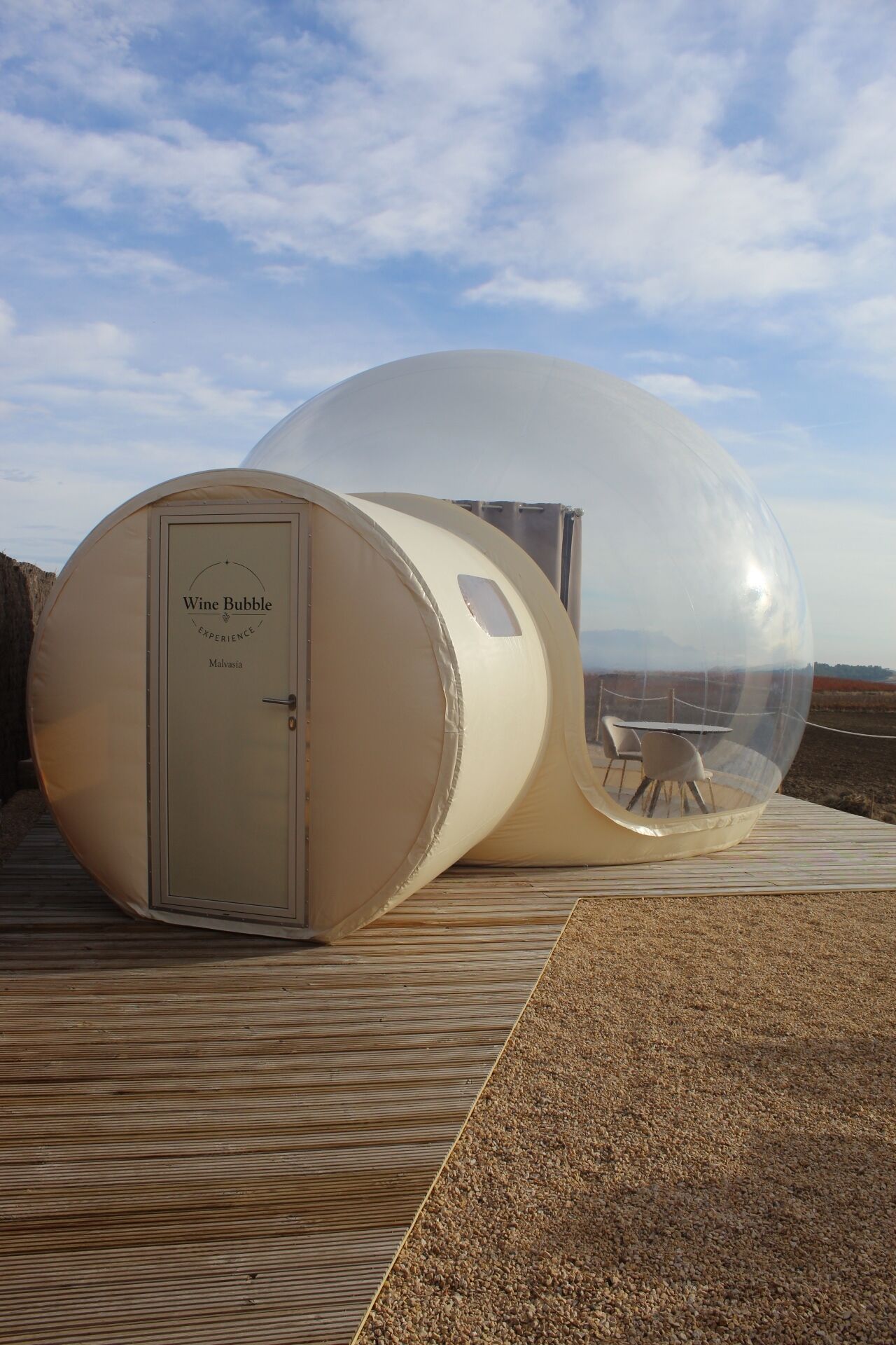 A spherical structure labeled "Wine Bubble Experience" with a door and a table inside.
