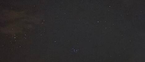 A dome-shaped structure with a clear roof, possibly a planetarium or observatory, under a starry night sky.