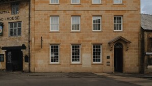 A two-story building with a symmetrical facade, multiple windows, and a central entrance with a decorative arch. - Luxury Stay in Heart of the Cotswolds (Cheltenham)
