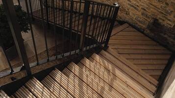 Un escalier en bois avec des rampes en métal menant à un niveau supérieur.