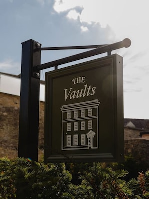 A sign for 'The Vaults' with a building illustration.