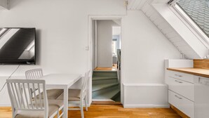 A modern kitchen with white cabinetry, a wooden countertop, and a dining area with white chairs. - Bergen Villa - Charming 3 Bedroom a View (Bergen)