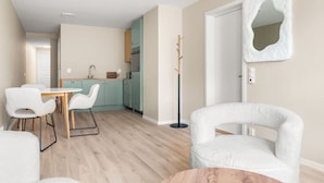 A modern living room with a dining area, a kitchen, and a hallway leading to another room. - Dream Apartment – Central Living at Its Best! (Bergen)