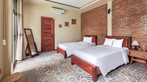 A hotel room with two beds, a brick wall, a patterned floor, and a wooden door. - 3BR Boutique Villa, Private Pool (Krong Siem Reap)
