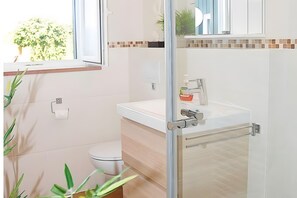 A modern bathroom with a toilet, sink, and shower area. - Apartment "Zum Torfstecher" in a quiet, central location with mountain views (Monschau)