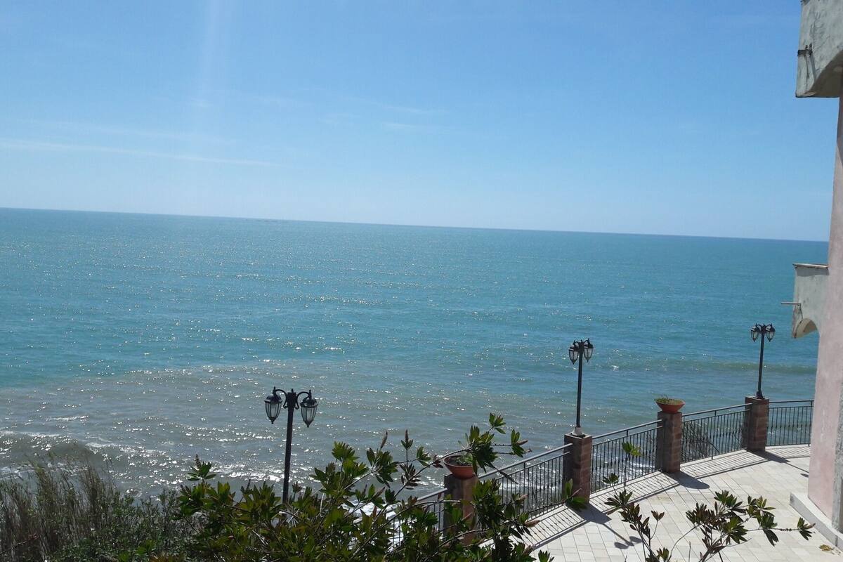 Une vue sur la côte, avec un bâtiment doté d’un balcon donnant sur la mer.