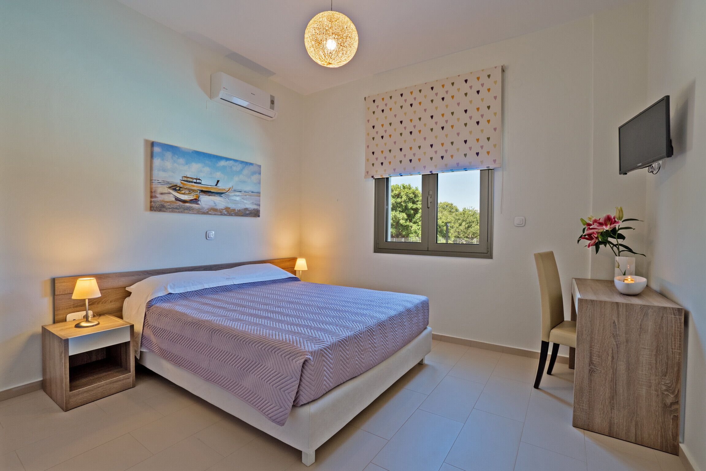 A bedroom with a bed, bedside tables, a TV, a window with a view, and a painting on the wall.