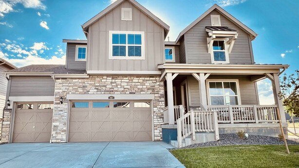 A two-story house with a stone facade, a garage, and a covered porch. - New spacious 4-bedroom house in serene Brighton with cool AC and fast Wi-Fi. (Brighton)