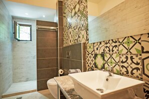 Ein Badezimmer mit Dusche, Toilette und Waschbecken.
