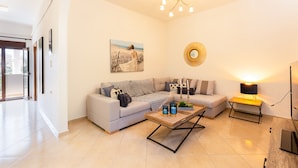 A living room with a sofa, a coffee table, a lamp, and a painting on the wall. - Stefanakos House (Agios Vasileios)